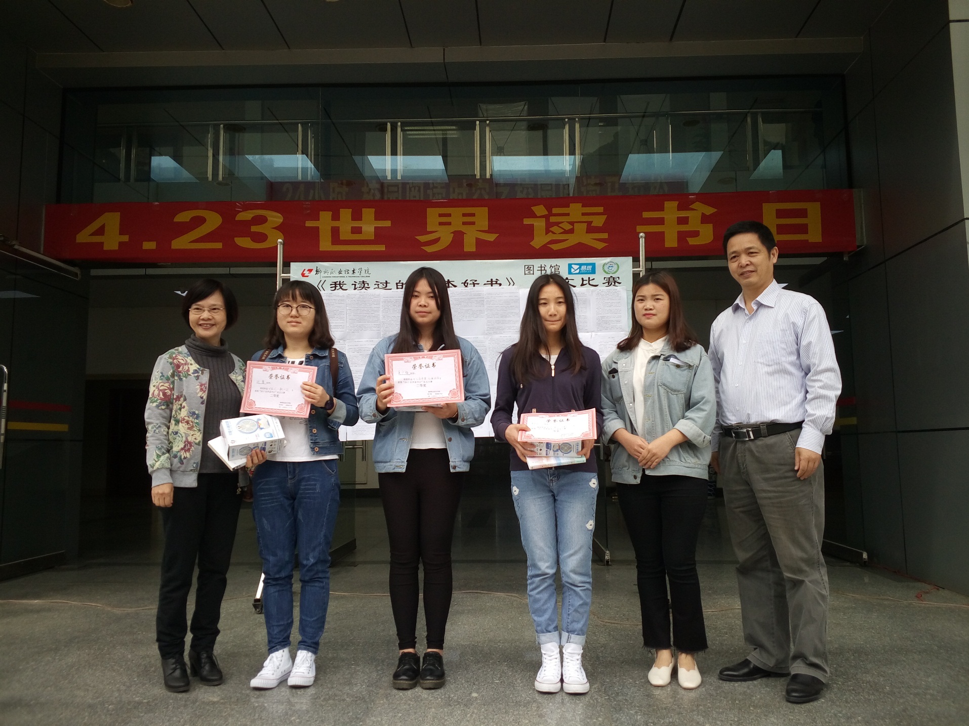 周静老师（左一）宋春晓同学（右二）谭界忠馆长（右一）为征文二等奖获得者颁奖